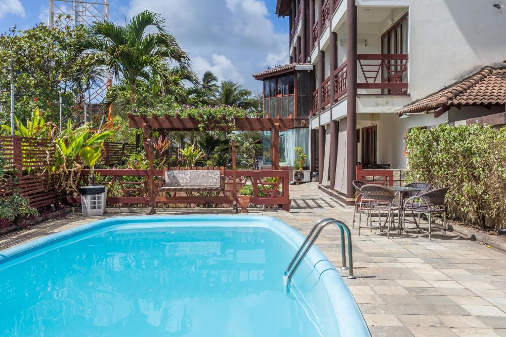 a swimming pool in front of a house at Pousada Iandê in Porto De Galinhas