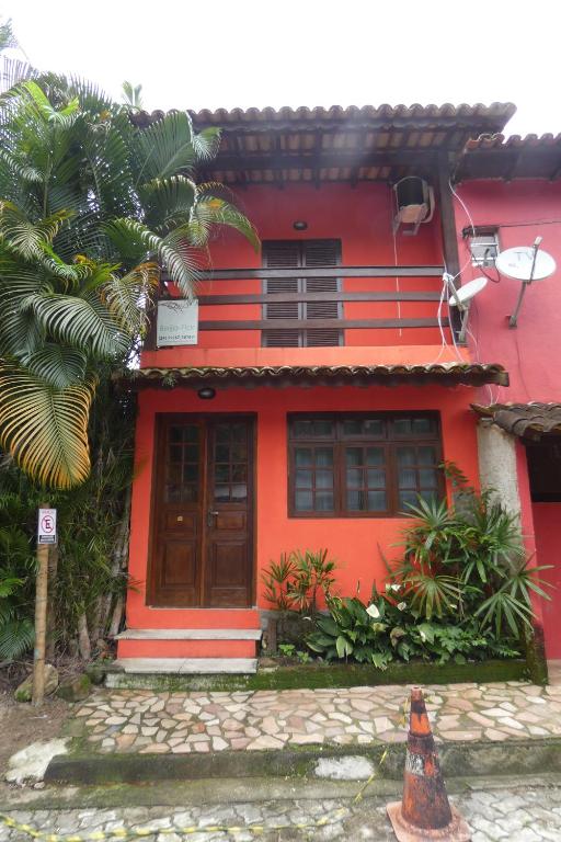 a red house with a dog in front of it at Casa Beija-Flor in Trindade