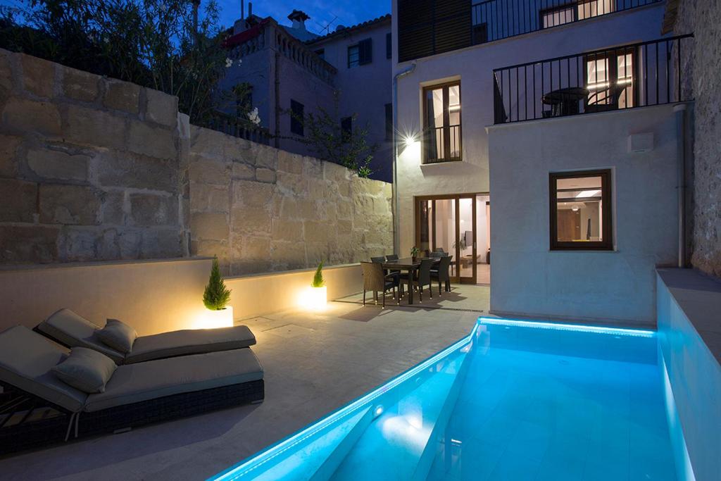 a house with a swimming pool at night at ANTIGUA CASA DE PUEBLO SANT SEBASTIA in Pollença