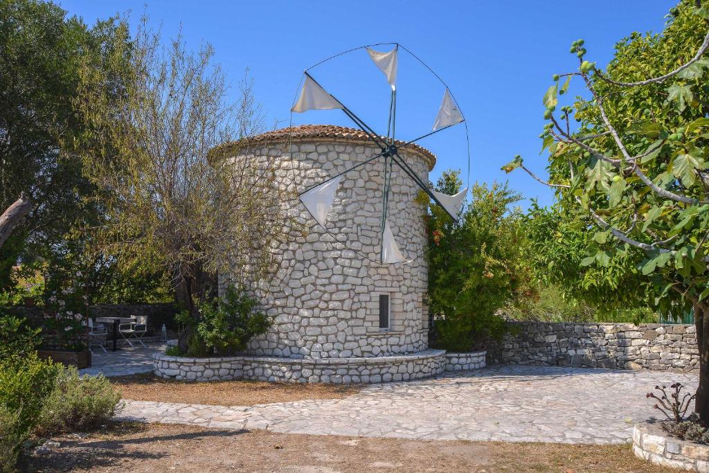 a stone tower with a kite on top of it at Milos Traditional Windmill in Mougkelátika