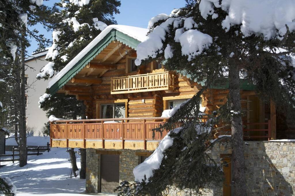 a log cabin with a deck in the snow at Chalet les SORBIERS, en rondins, classé 4****étoiles in Bolquere Pyrenees 2000