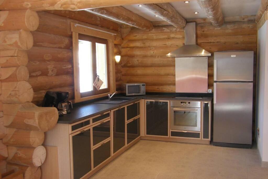 a kitchen in a log cabin with a refrigerator at Chalet les SORBIERS, en rondins, classé 4****étoiles in Bolquere Pyrenees 2000