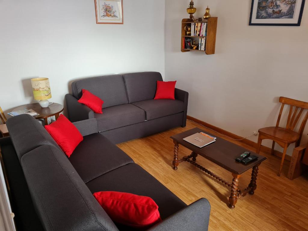 a living room with a gray couch and red pillows at Maison à Font-Romeu - Odeillo in Odeillo-Via