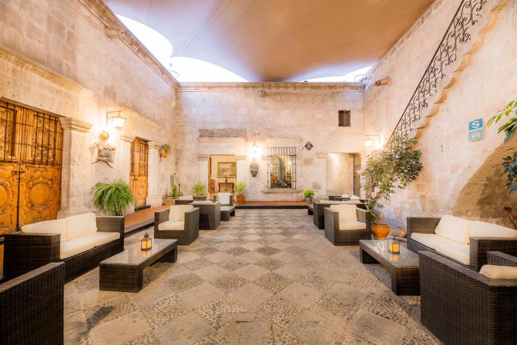 a lobby with couches and tables in a building at Hotel Los Tambos Colonial in Arequipa