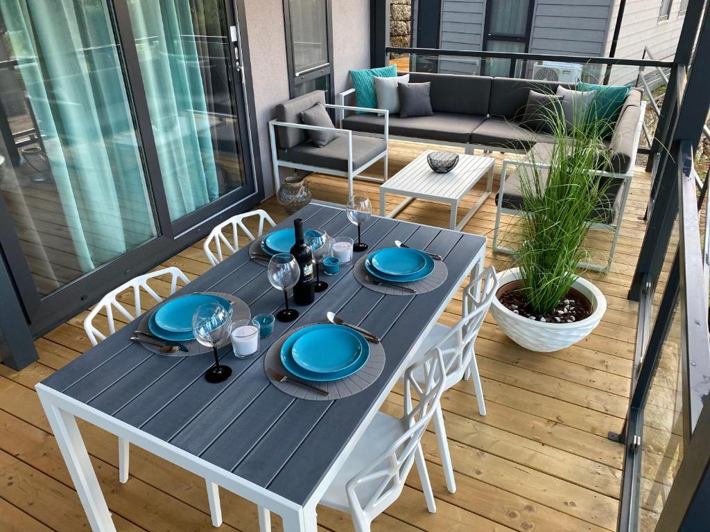 - une table avec des plaques bleues sur la terrasse dans l'établissement Mobile Home DIVINA Camp Porton Biondi, à Rovinj