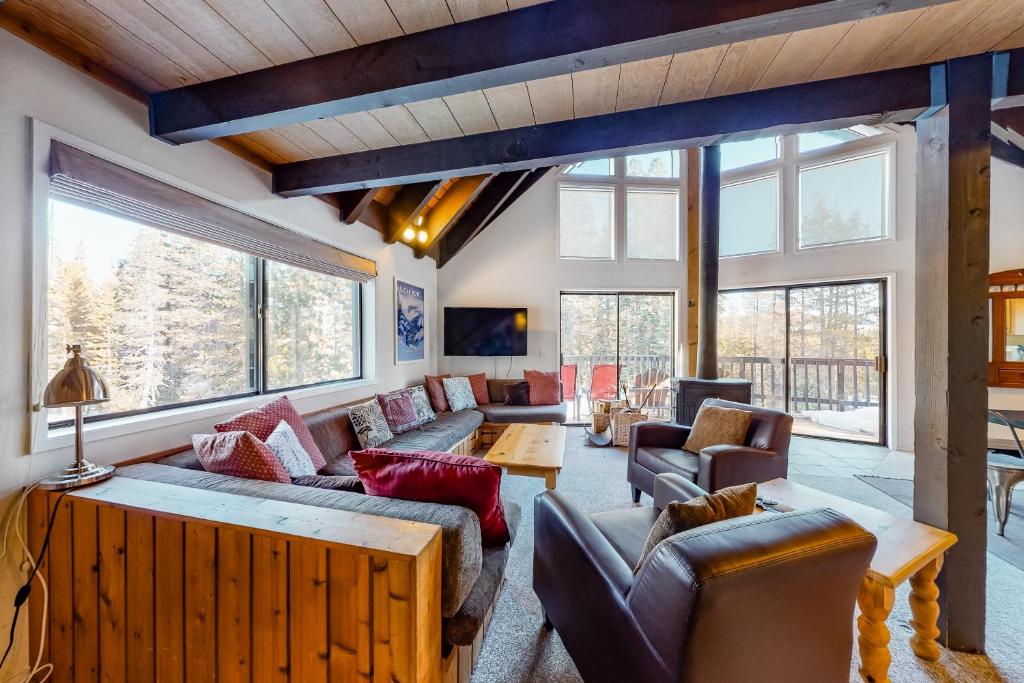 a living room with couches and chairs and windows at Hillside Haven in Soda Springs