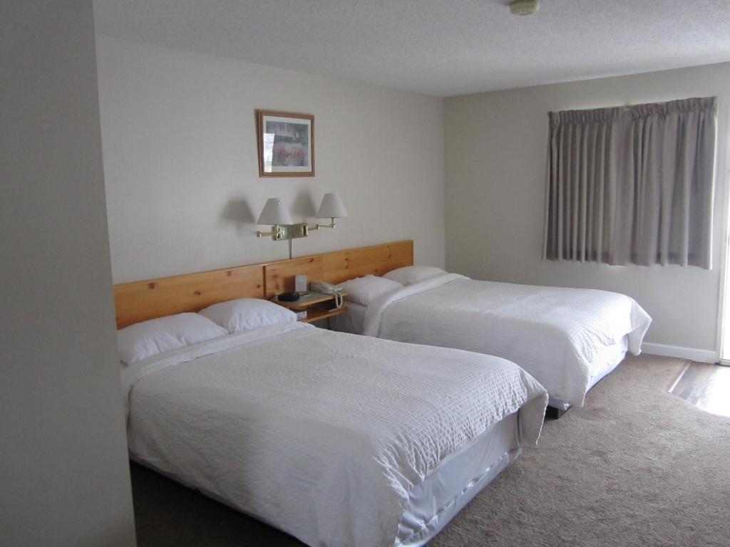 史密瑟斯的住宿－雜草汽車旅館，酒店客房设有两张床和窗户。