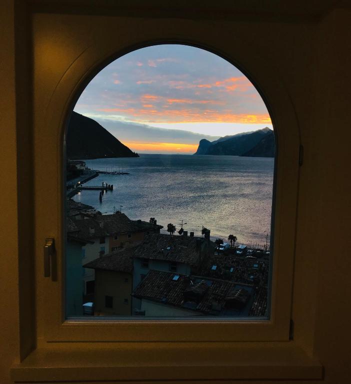 a window with a view of the ocean and a city at Wind Rose Apartments 2 in Nago-Torbole
