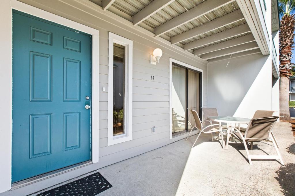 una porta blu su una casa con tavolo e sedie di Peach Seashell a Destin
