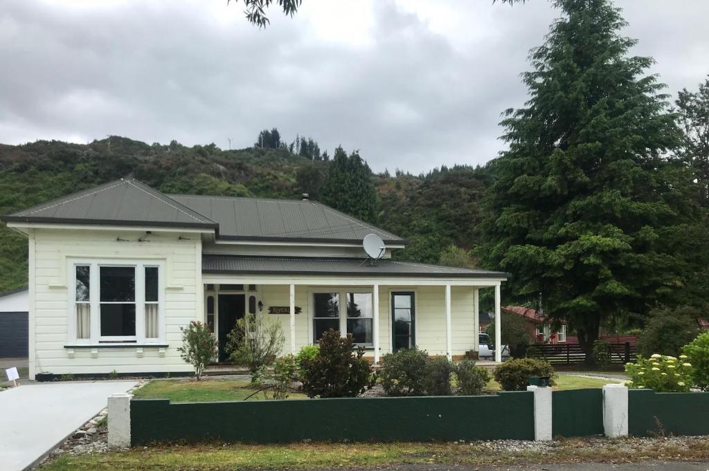 a white house with a black roof at The Old Vicarage in Reefton