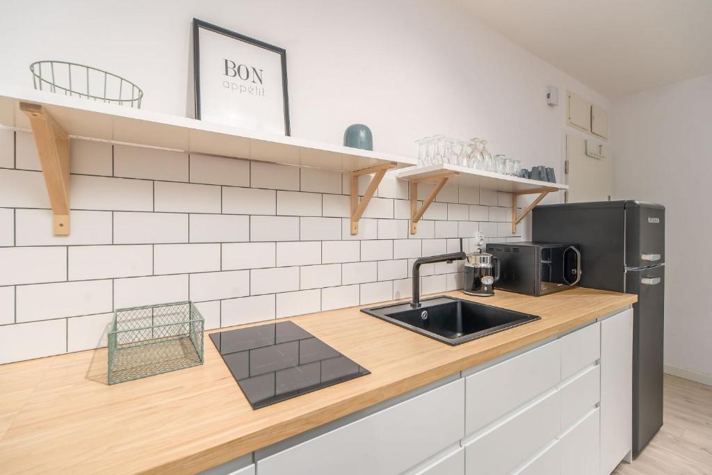 a kitchen with a sink and a refrigerator at FARO Apartamenty Bliżej Morza in Kołobrzeg