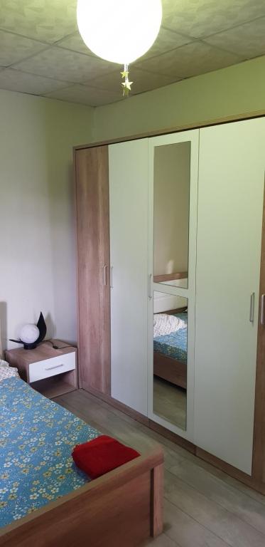 1 dormitorio con cama y espejo grande en Joli F3 à une minute de la plage en Bouéni