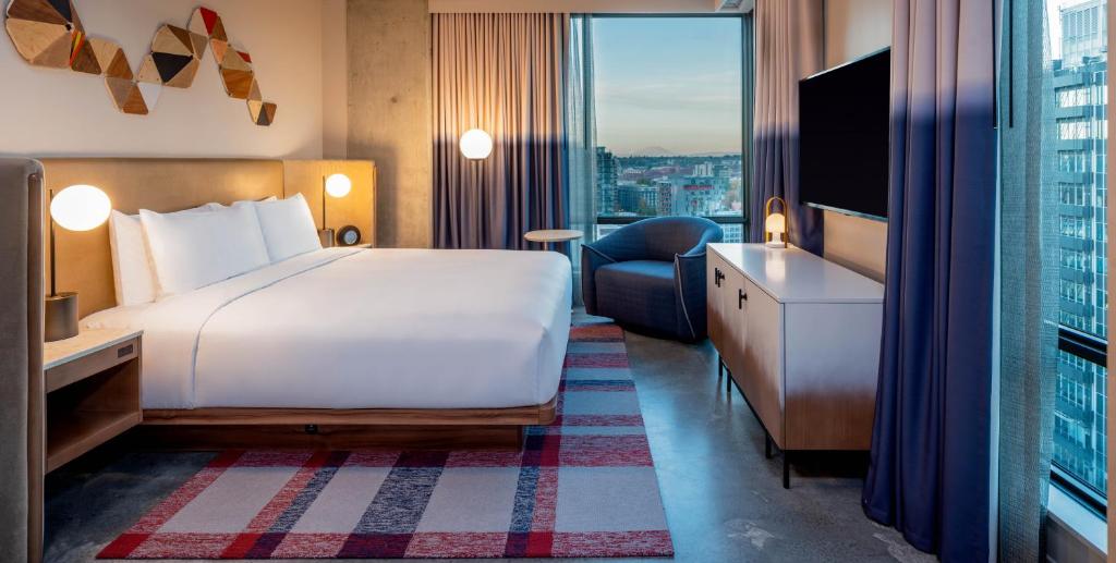 a hotel room with a bed and a large window at Hyatt Centric Downtown Portland in Portland