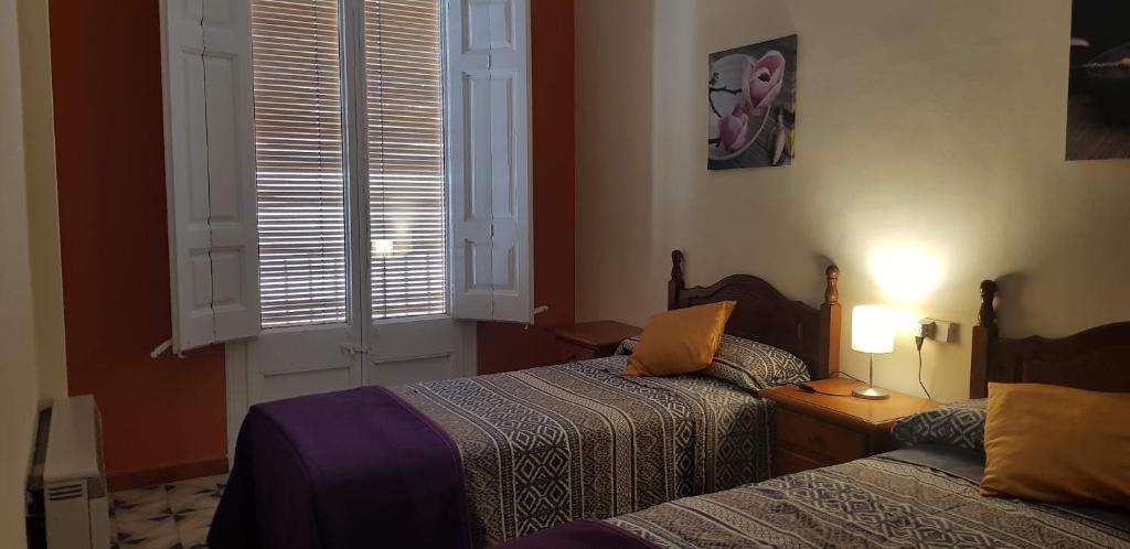 een hotelkamer met 2 bedden en een raam bij Piso romantico y espacioso in Tremp