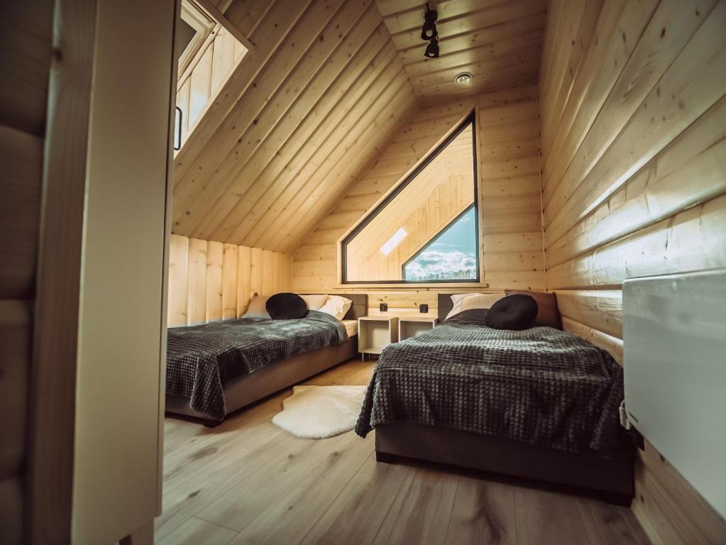 マクフ・ポトハランスキにあるCzillChata - dom z baliąの木造家屋内のベッドルーム(ベッド2台付)