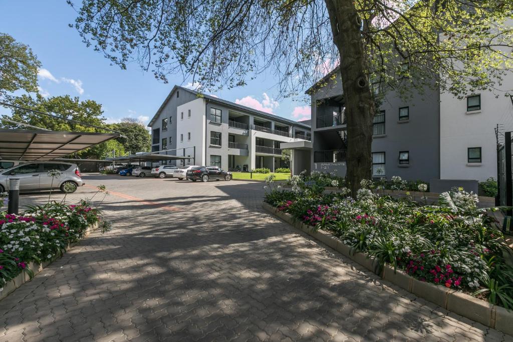 a walkway in front of a building with flowers at Stay Ulo at Atholl Gate in Johannesburg