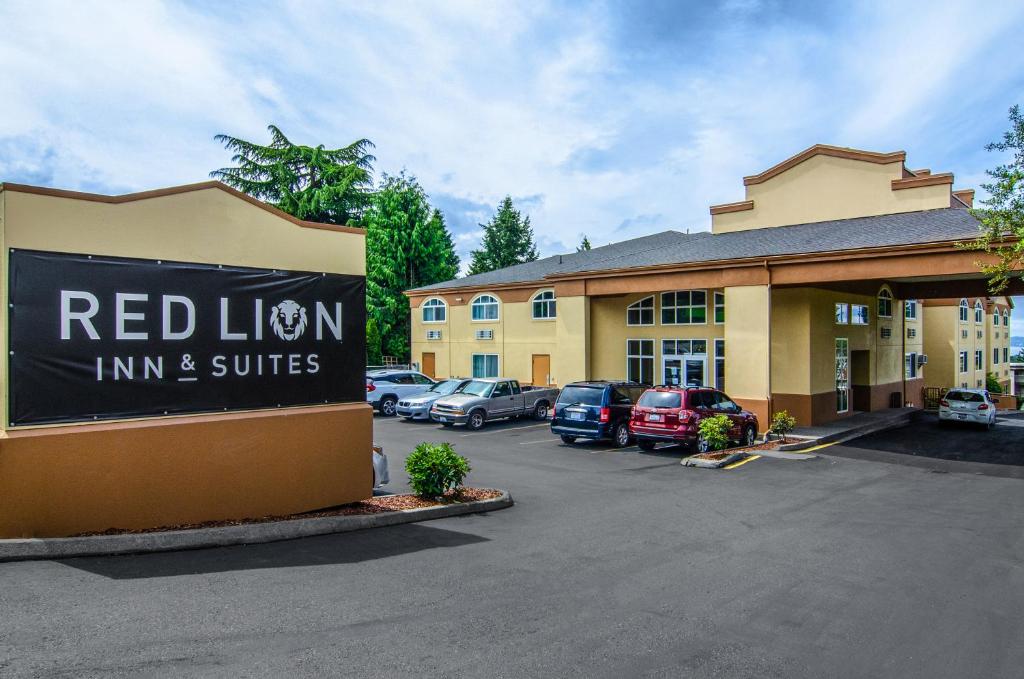 Una posada de leones rojos y suites firman delante de un estacionamiento en Red Lion Inn & Suites Des Moines, en Des Moines