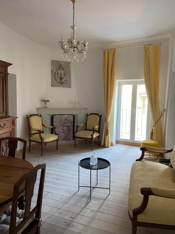 - un salon avec des chaises, une table et un lustre dans l'établissement Charmant appartement dans un immeuble du 15ème siecle, à Sartène