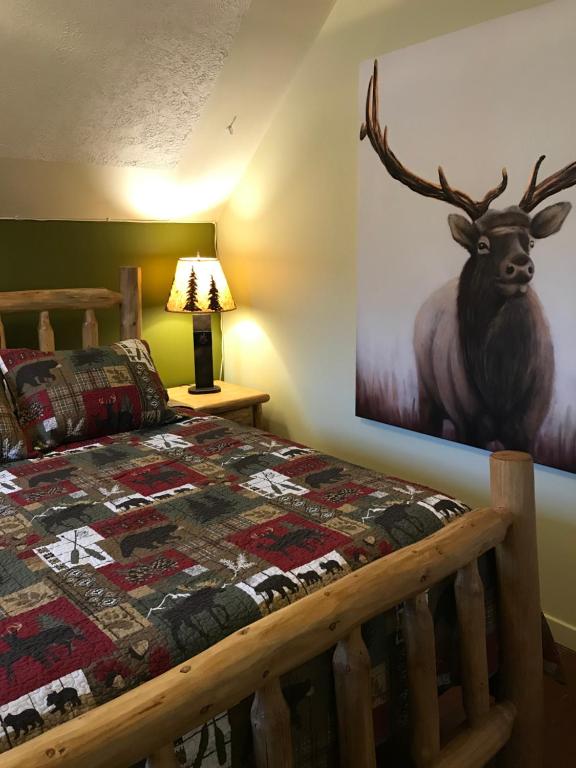 a bedroom with a bed and a picture of a deer on the wall at Holiday Lodge Bed and Breakfast in Banff