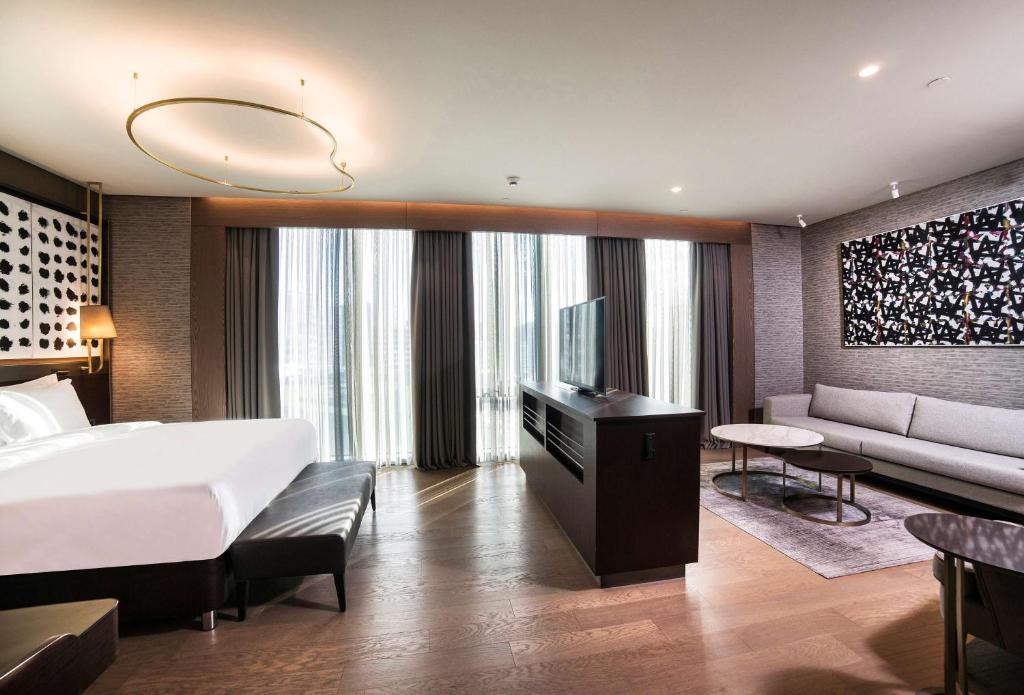a bedroom with a bed and a couch and a tv at Radisson Collection Hotel, Vadistanbul in Istanbul