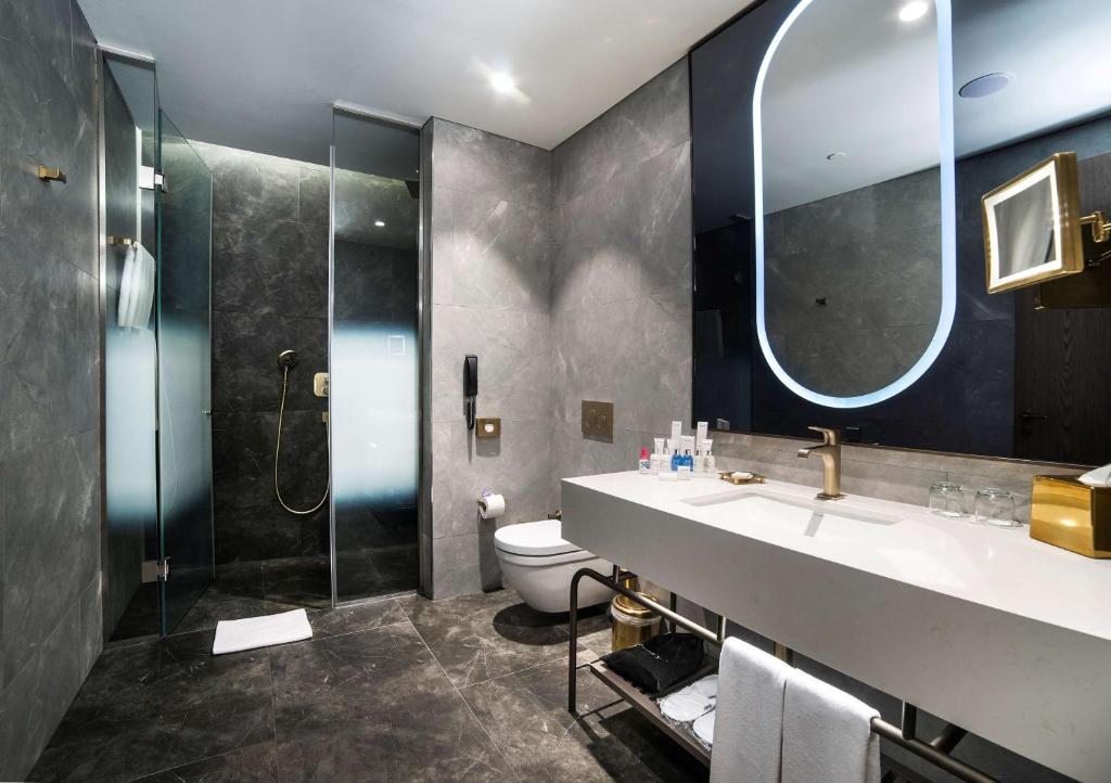 a bathroom with a sink and a shower and a toilet at Radisson Collection Hotel, Vadistanbul in Istanbul