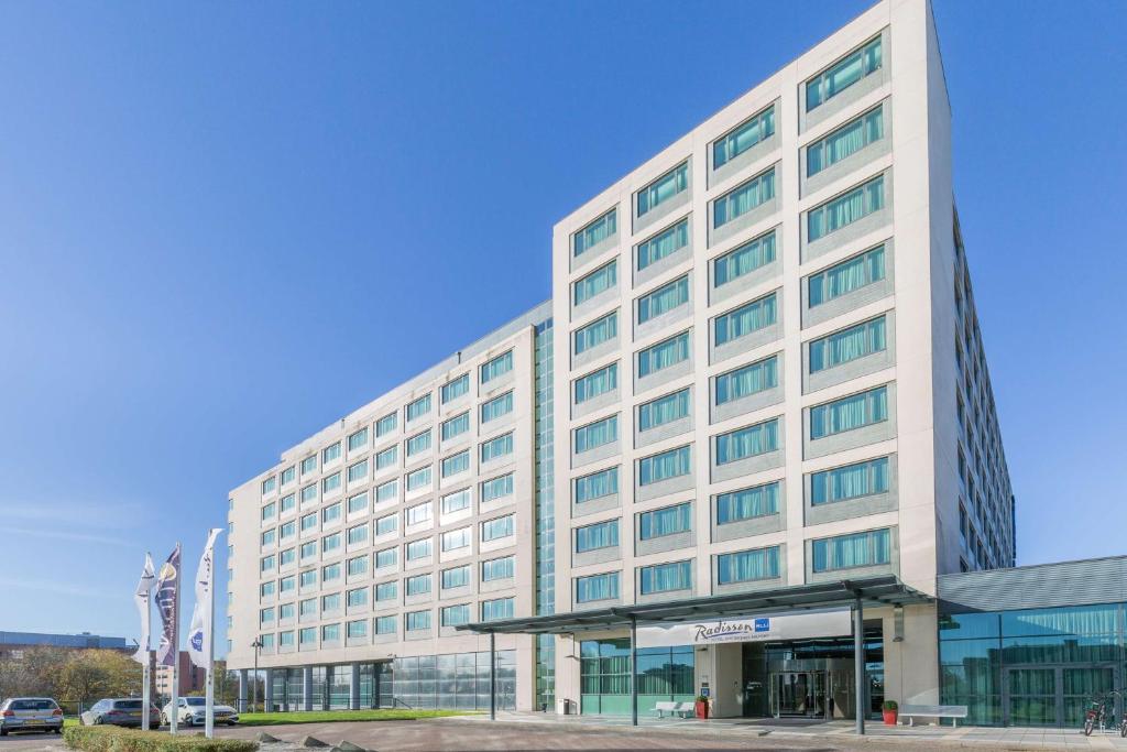 a large white building with a lot of windows at Radisson Blu Hotel Amsterdam Airport, Schiphol in Schiphol