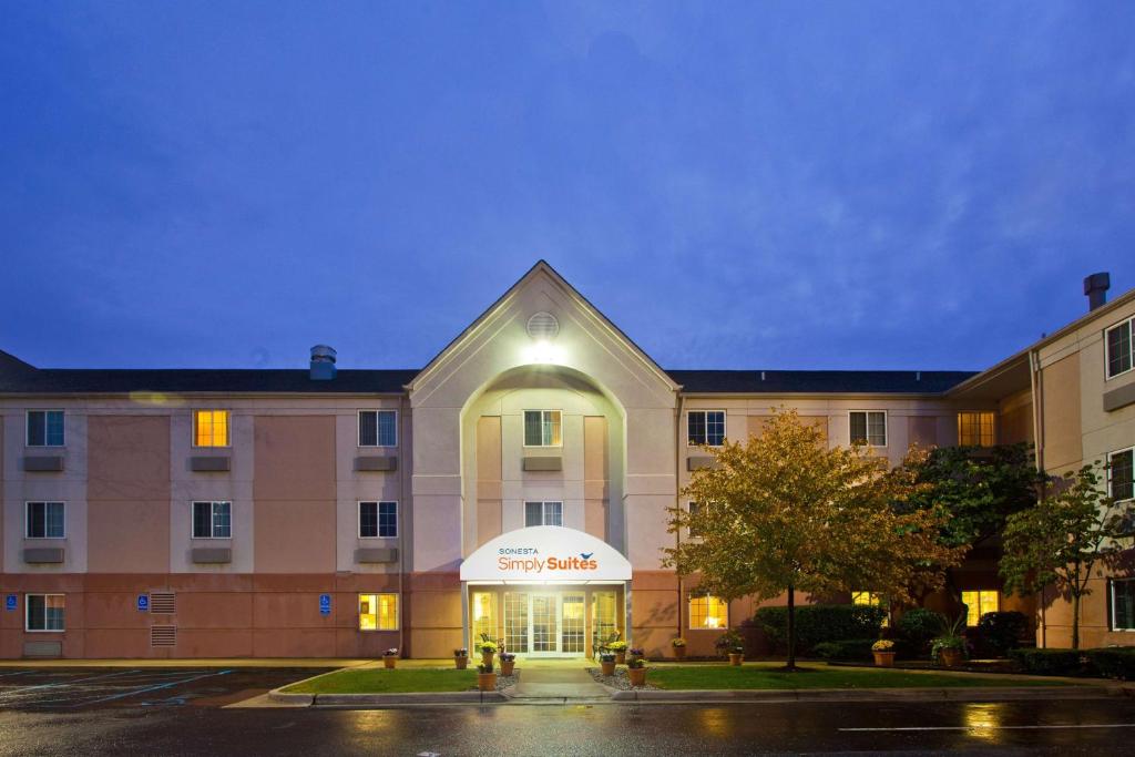 a hotel front of a building at night at Sonesta Simply Suites Detroit Warren in Warren