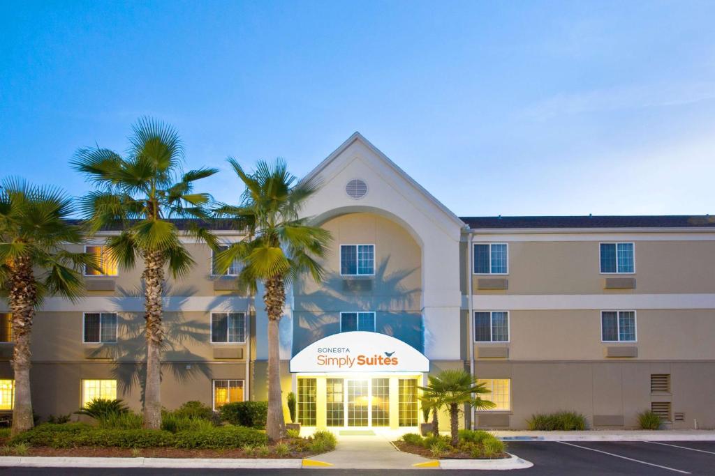 a large building with palm trees in front of it at Sonesta Simply Suites Jacksonville in Jacksonville