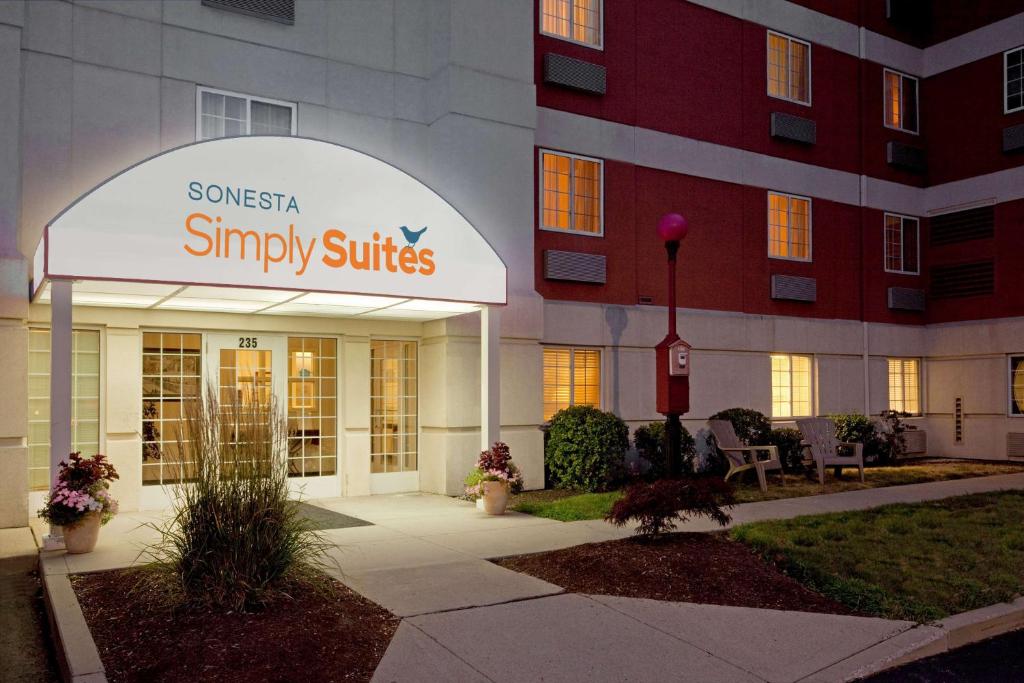a sign for a snyasy suites in front of a building at Sonesta Simply Suites Boston Braintree in Braintree