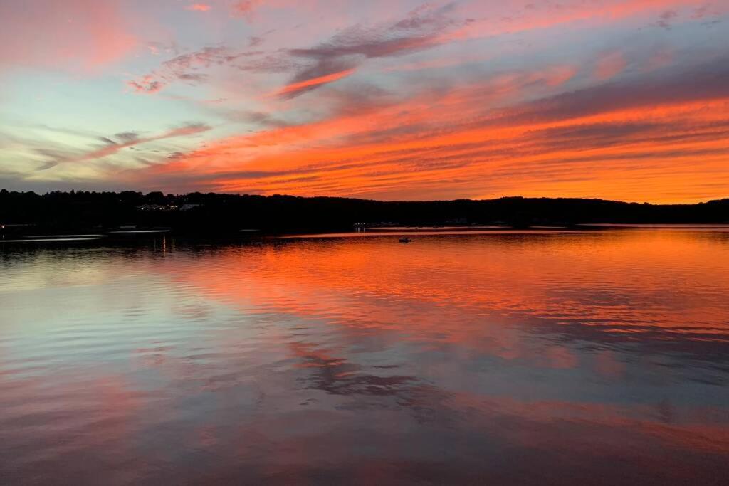 a sunset over a body of water with the sky at Waterfront Home with a View in Groton