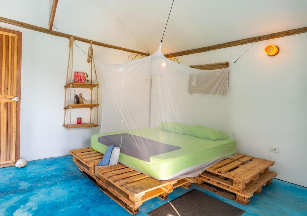 a room with a bed in a tent at El Zoo Hostel, Bar & Pool in Palomino