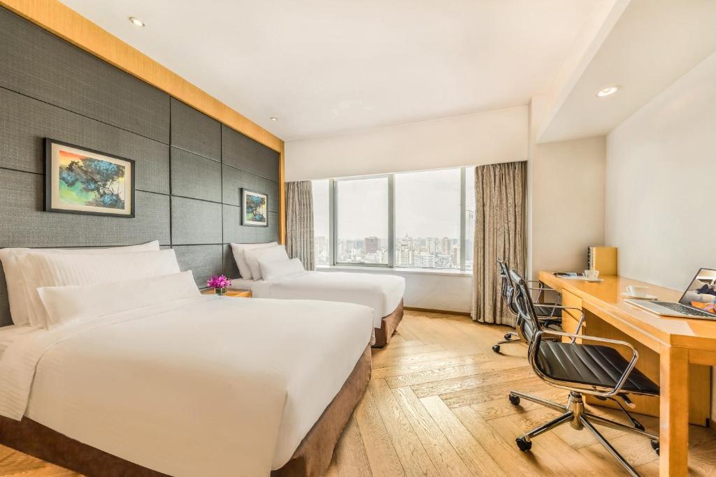 a hotel room with two beds and a desk at Somerset Riverview Chengdu in Chengdu