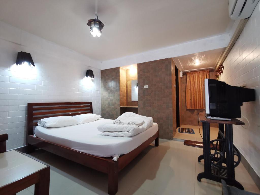 a bedroom with a bed and a flat screen tv at Baan Lanna Resort in Chon Buri