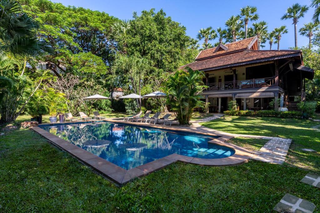 a swimming pool in the yard of a house at La Palmeraie D'angkor in Siem Reap