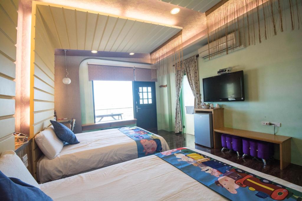 a hotel room with two beds and a tv at Lanyang Beach Villa in Wujie