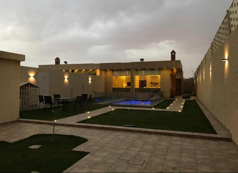 a house with a backyard with a swimming pool at شالية زهر in Unayzah