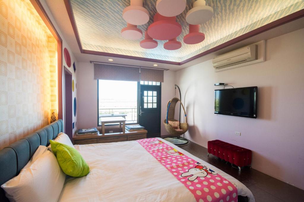 a bedroom with a large bed and a tv at Lanyang Beach Villa in Wujie