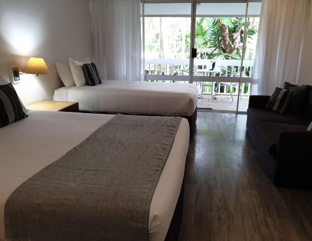 a hotel room with two beds and a couch at Rainforest Castaways Resort and Spa in Mission Beach