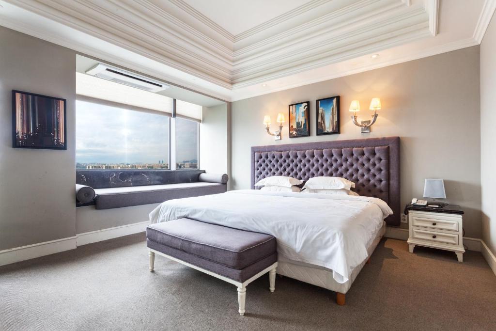 Un dormitorio con una cama grande y una ventana en The Riverside Hotel, en Seúl