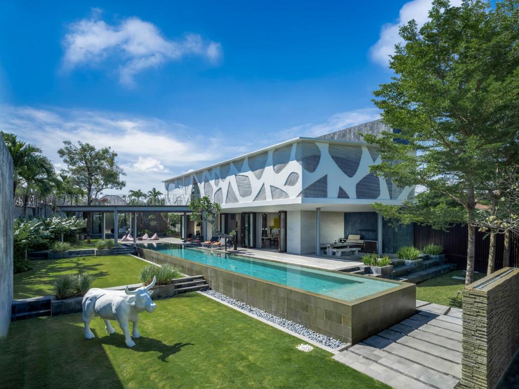 a house with a pool and a cow statue in the yard at Villa Issi by Elite Havens in Seminyak