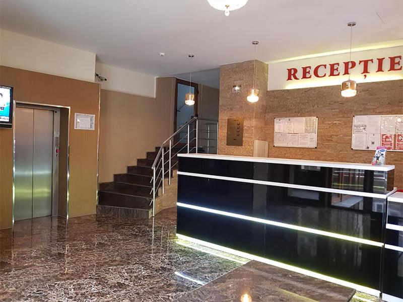 a lobby with a staircase and a reception desk at Hotel Uranus in Bucharest