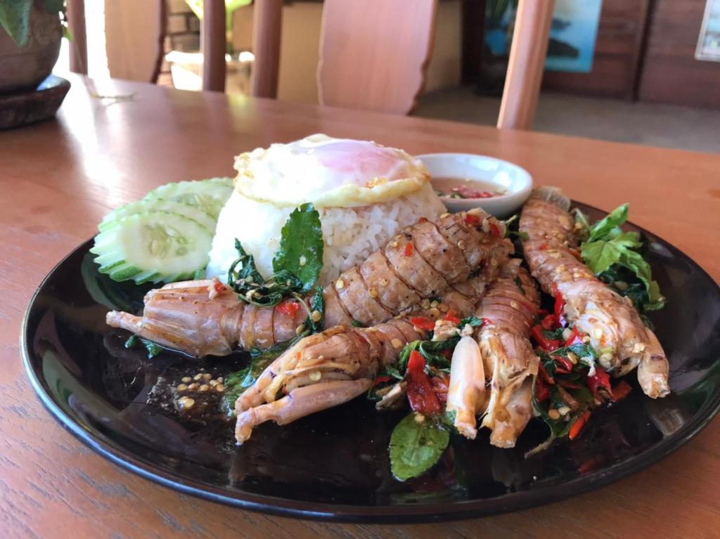 a plate of food with shrimp and rice on a table at Beck's Resort in Haad Pleayleam