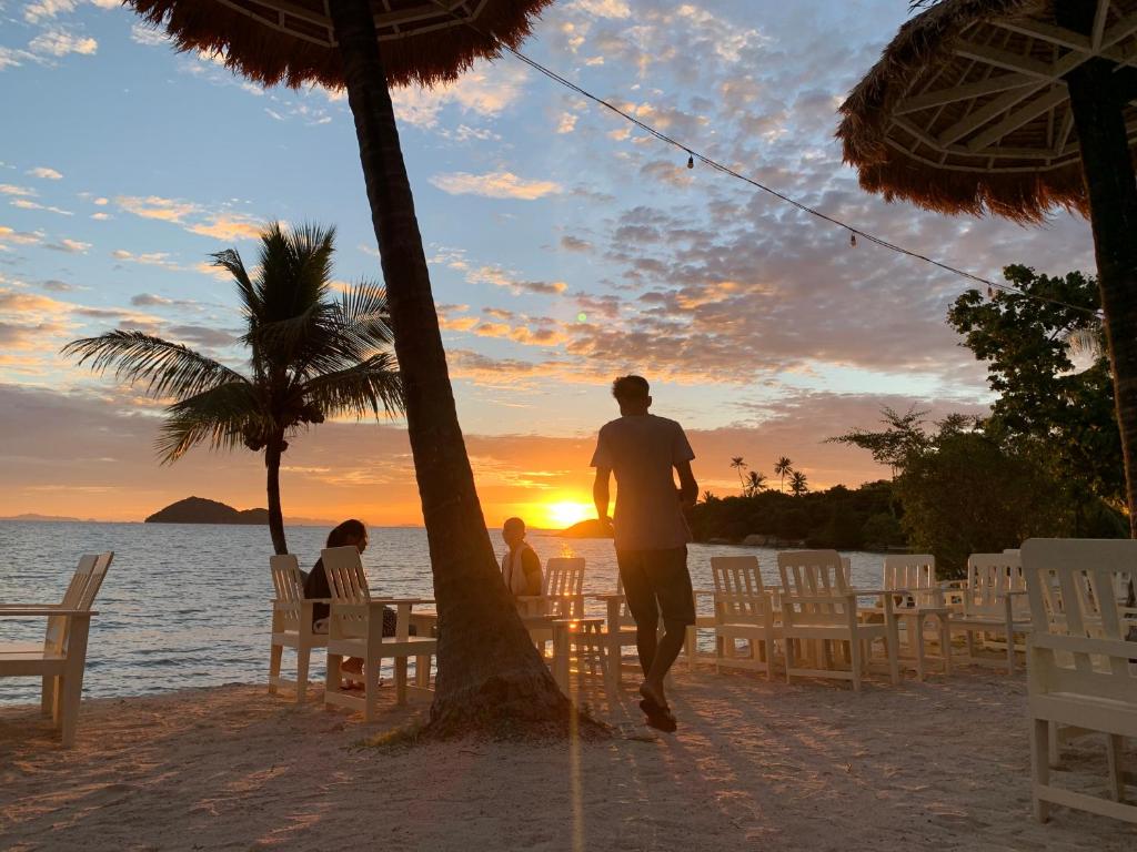 a man walking on the beach at sunset at Beck's Resort in Haad Pleayleam