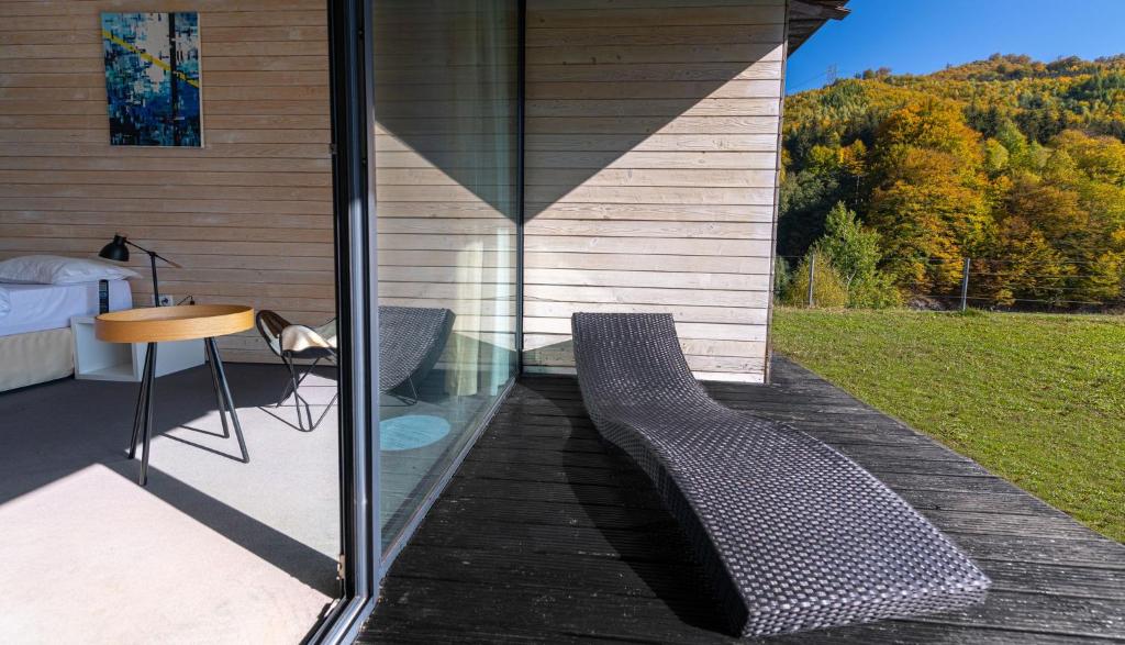 a patio with a chair and a table and a window at Pensiunea Atra Doftana in Teşila