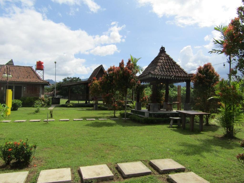 um jardim com uma mesa de piquenique e um pavilhão em Balkondes Bumiharjo (Kampung Dolanan) em Magelang