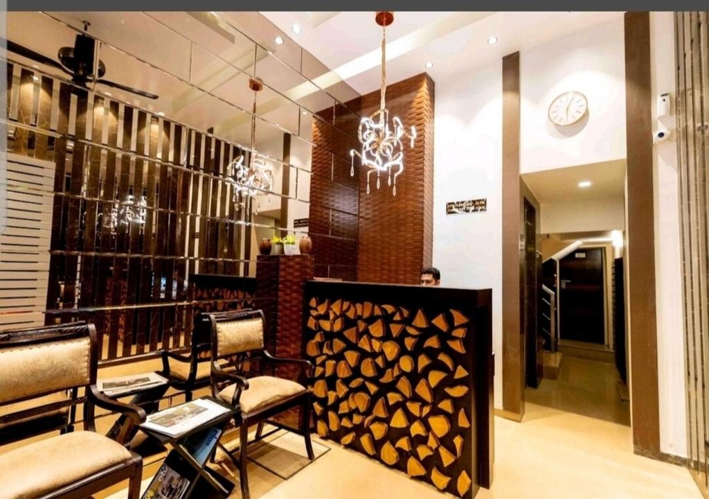 un restaurant avec un bar doté de chaises et d'un lustre dans l'établissement The Fountain Inn - Fort, à Mumbai