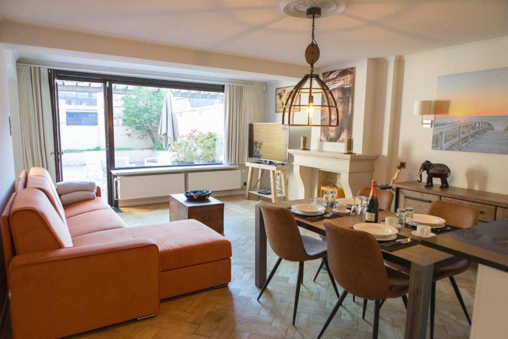 ein Wohnzimmer mit Couch und Tisch in der Unterkunft Centraal gelegen gezellig verblijf met groot terras in Ostende
