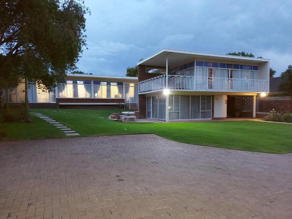 a large house with a large lawn in front of it at Goedgedacht Guestrooms in Potchefstroom