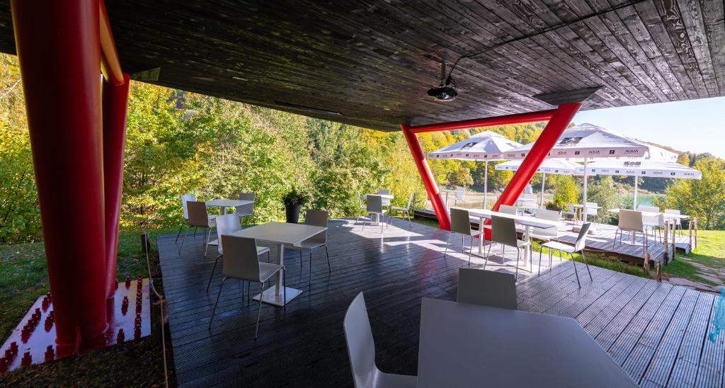 a patio with white tables and white chairs at Pensiunea Atra Doftana in Teşila
