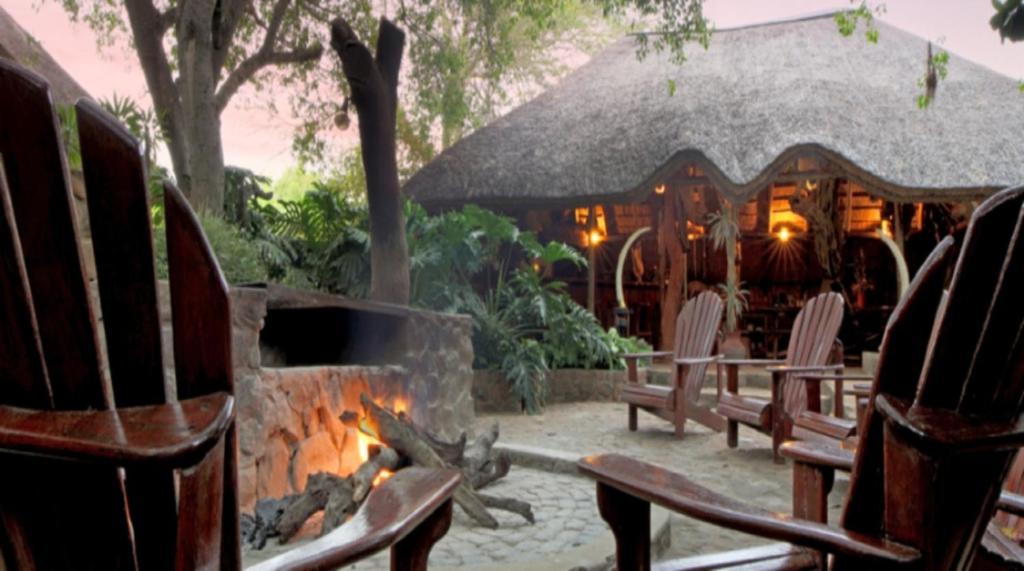 een groep stoelen naast een vuurplaats bij Valamanzi Lodge in Nyati Wilderness in Vaalwater